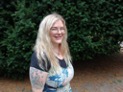 A person smiling in front of a bushAI-generated content may be incorrect.